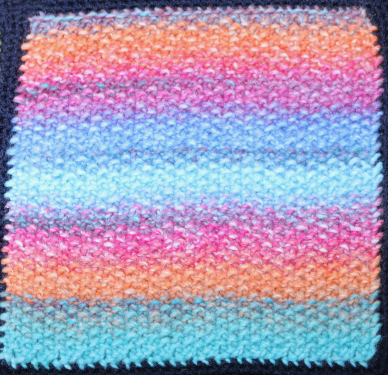 Knitted square: Horizontal stripes in blue, orange and pink