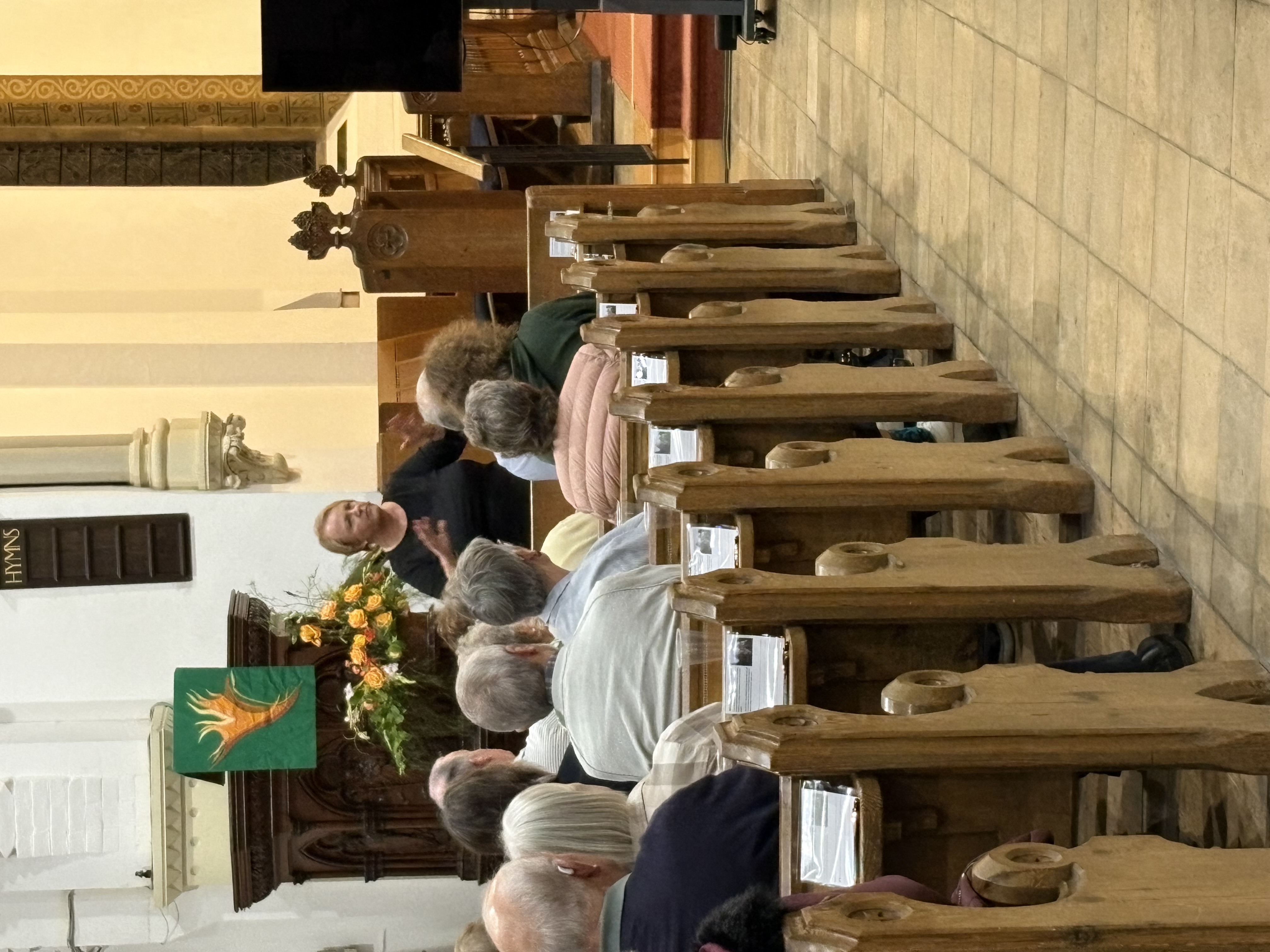 Janice Brooks talking to a group of people sitting in church pews