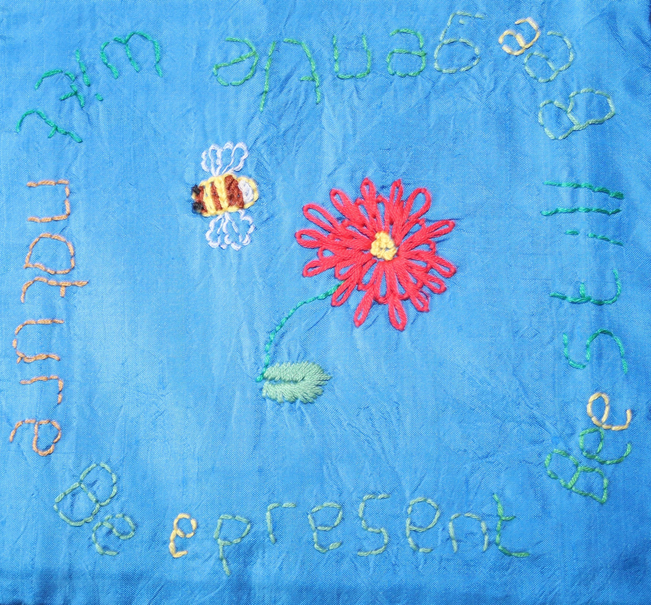 Embroidery of bee, flower and a saying