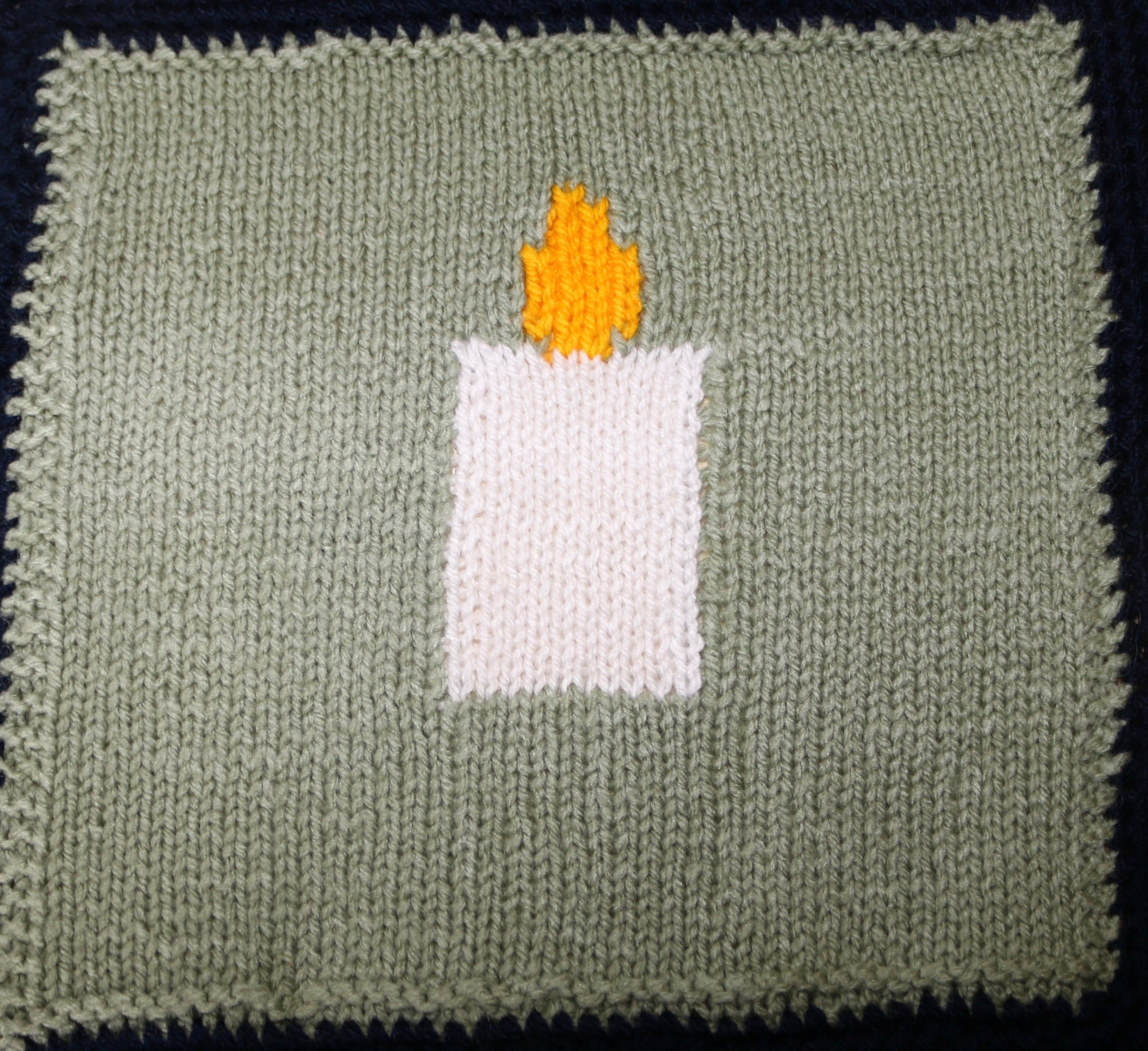 Knitted square of a Lit candle