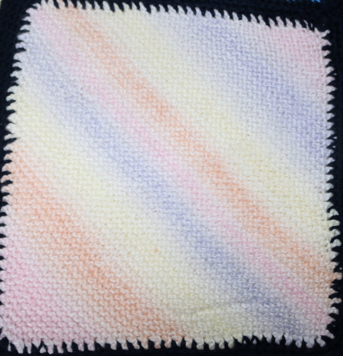 Knitted square - diagonal lines in pink, orange, yellow, blue, purple