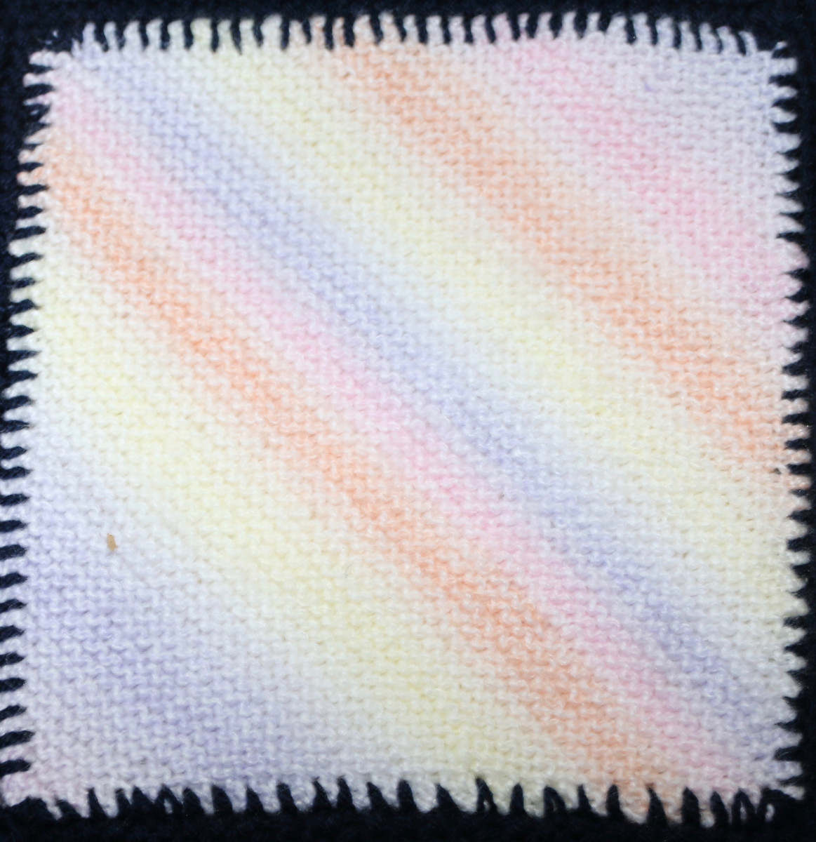 Knitted square - diagonal lines in pink, orange, yellow, blue, purple
