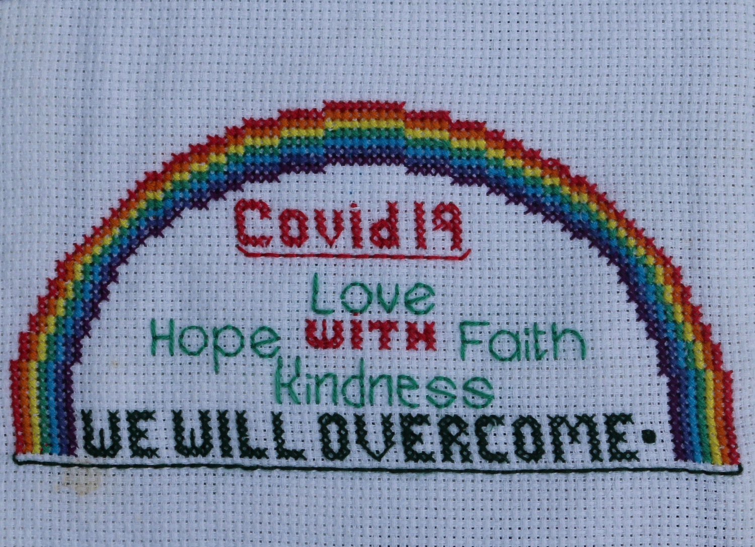Embroidery of a rainbow and words: Covid 19, Love, Hope with Faith, Kindness, We will overcome