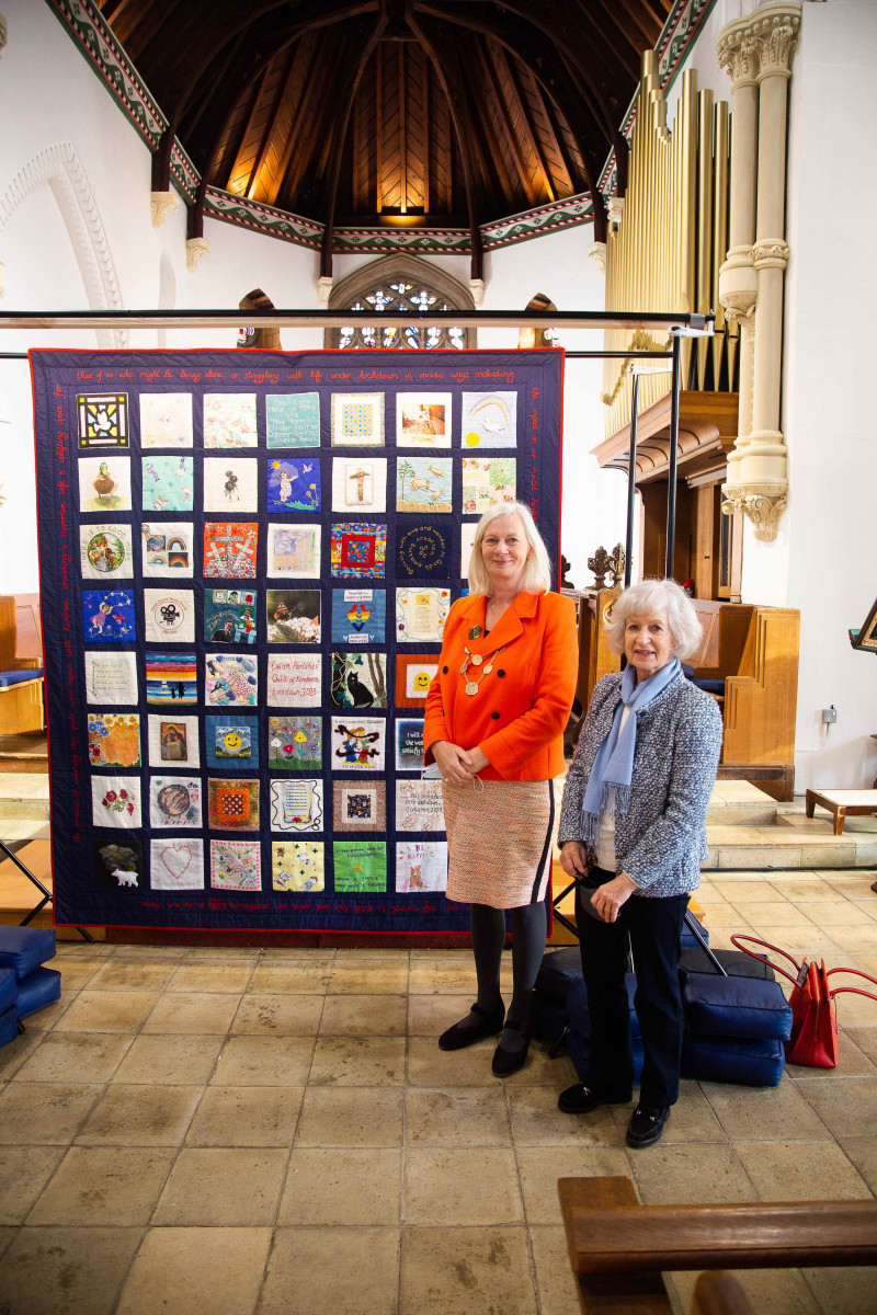 Sheriff of Norwich and one of quilt makers in front of a textile quilt